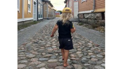 Lapsi kävelee paljain jaloin kivetyksellä Vanhassa Raumassa.
